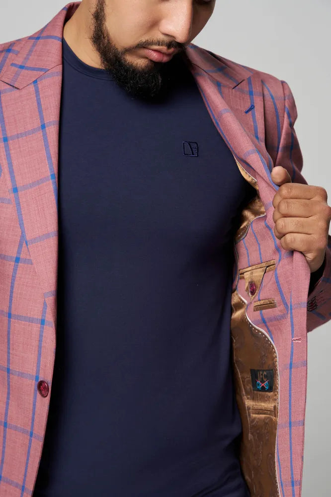 a man is wearing blue t shirt with pink coat