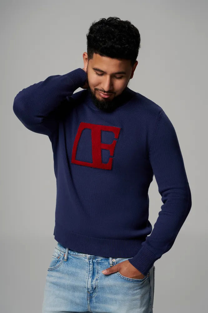 a boy is wearing Blue-Red Label Sweater looking down