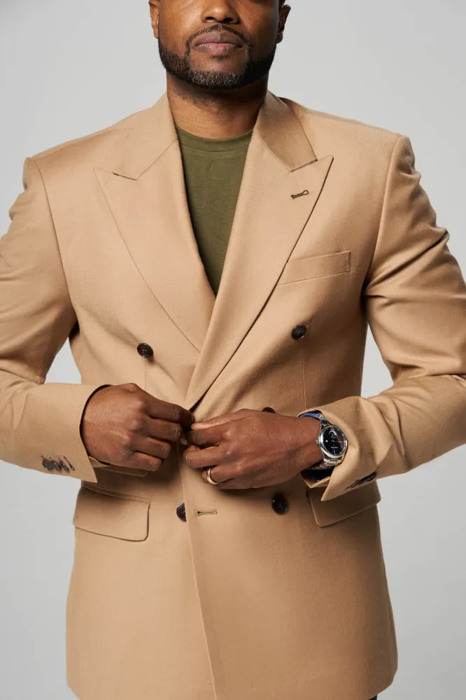 a man is wearing a brown coat with forest green t shirt inside