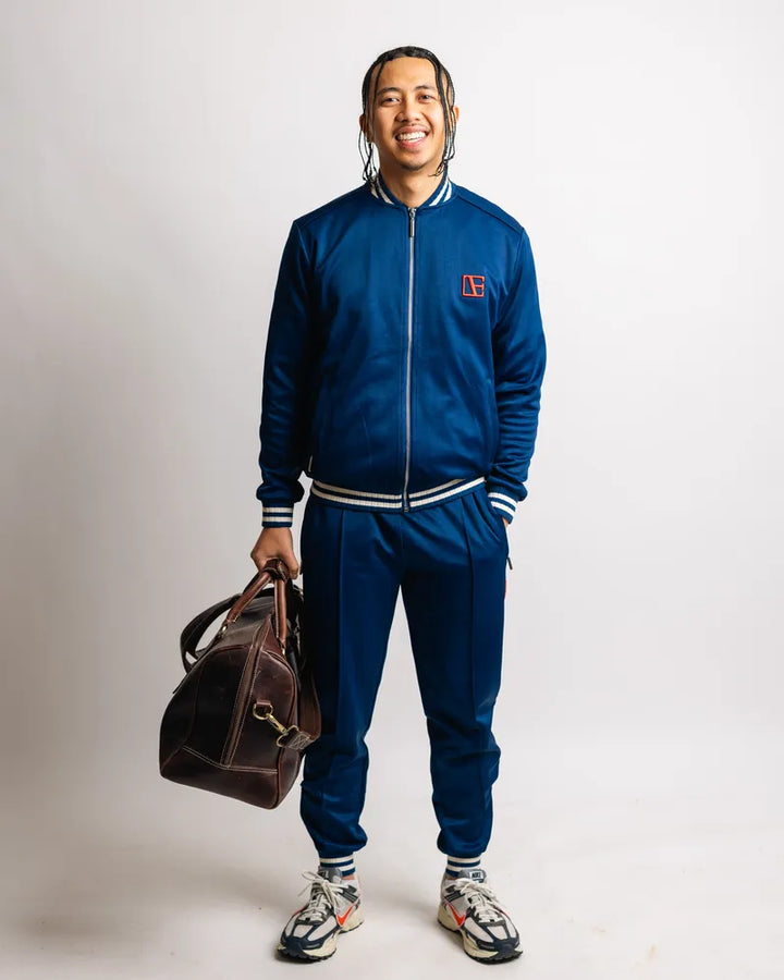 a man is wearing Blue Tracksuit while holding a pack
