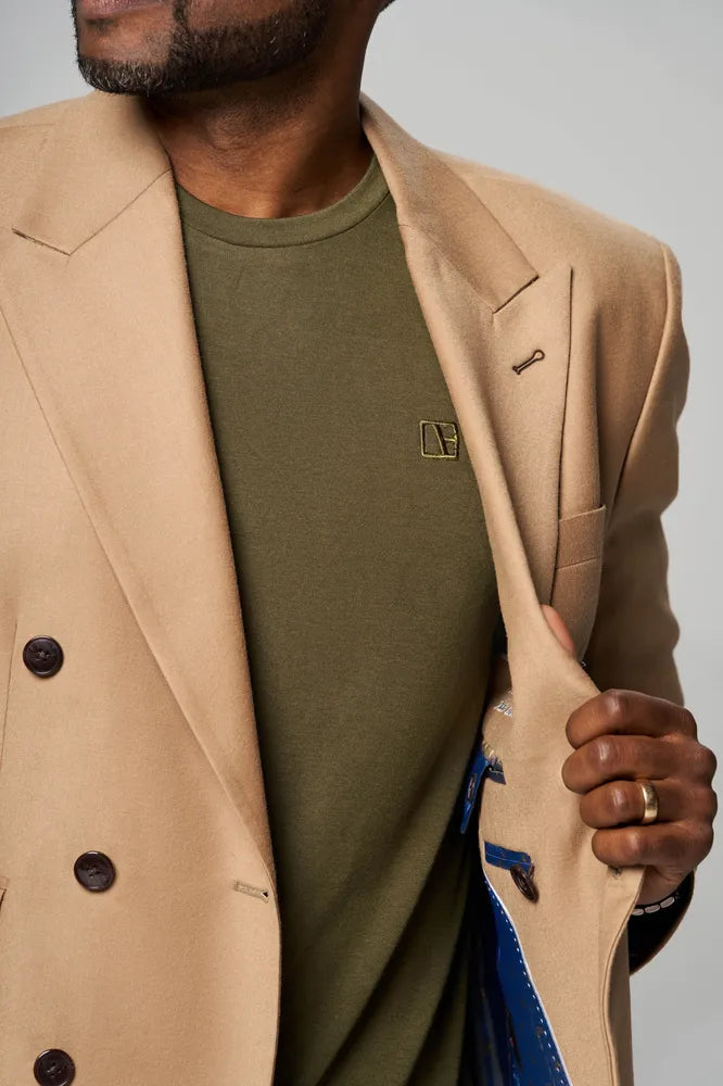a man is wearing forest green t shirt with brown color coat