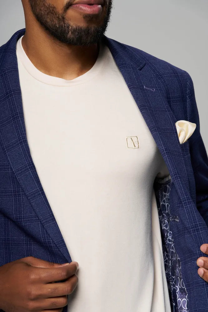 a man is wearing blue coat with cream color t shirt