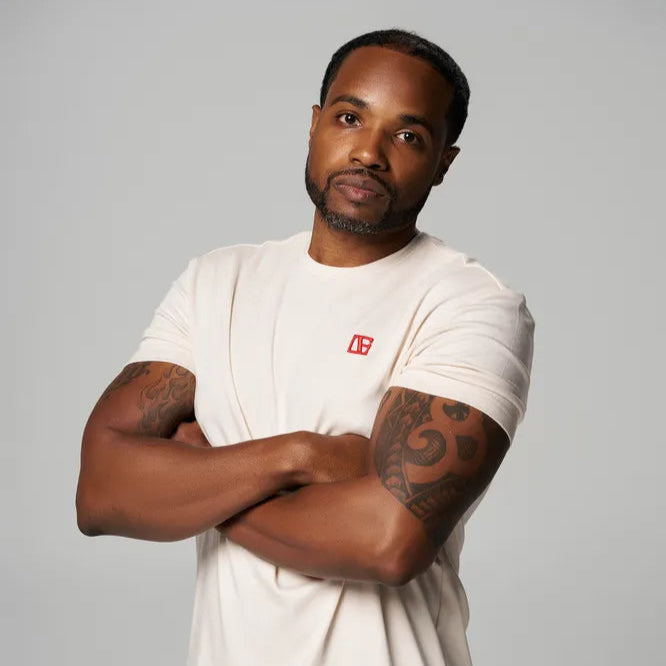 a man is wearing cream color t shirt with red etn logo