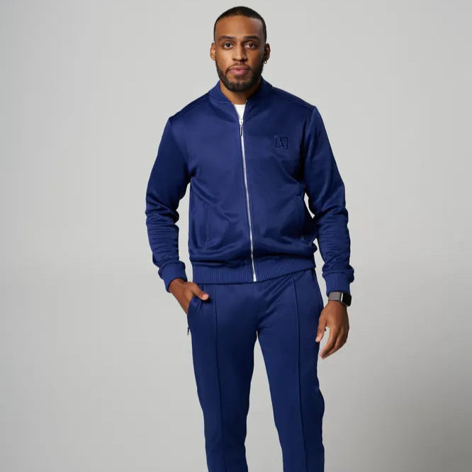 a man is standing wearing Blue Tracksuit