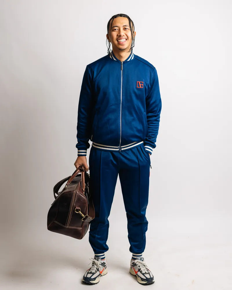 a man is wearing Blue Tracksuit while holding a pack