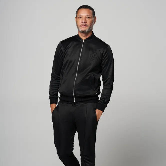 a man is wearing the black tracksuite